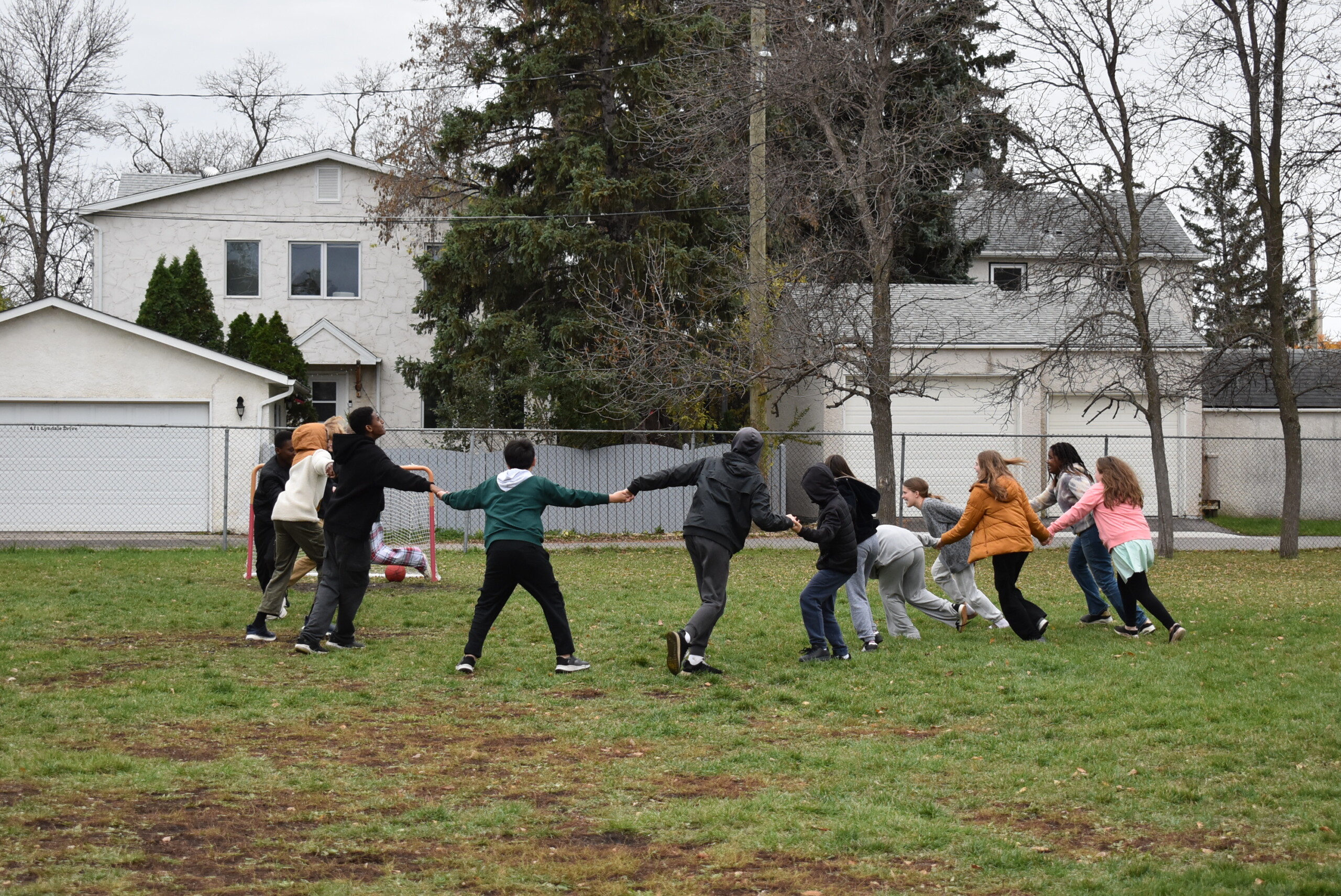 Students holding hands and playing outside.